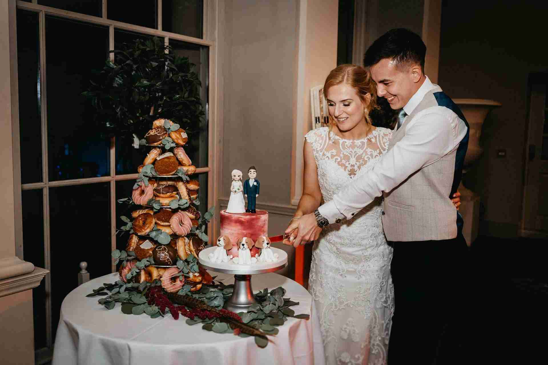 STUBTON HALL | Amelia & Tom 20 Bride and groom cutting wedding cake at Stubton Hall wedding venue