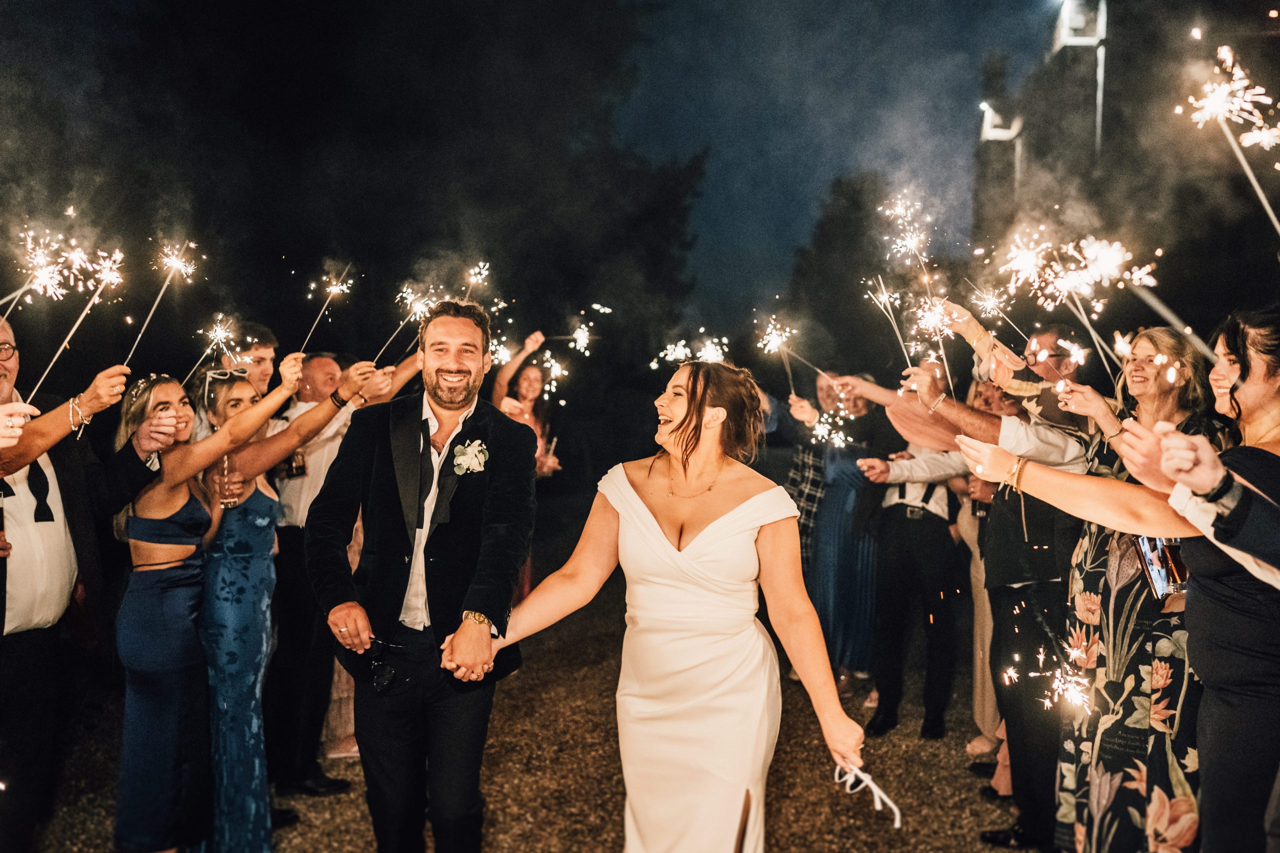 HOME 20 a man and woman holding hands and walking with sparklers