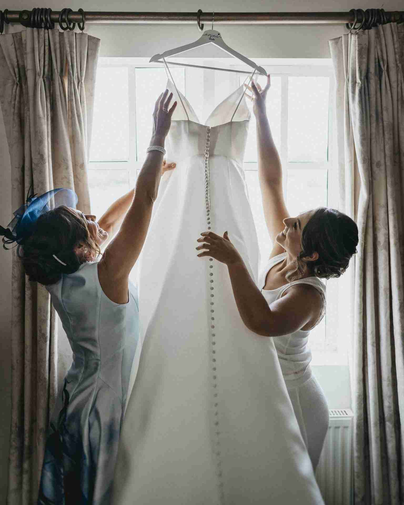 PORTFOLIO 59 two women holding a dress